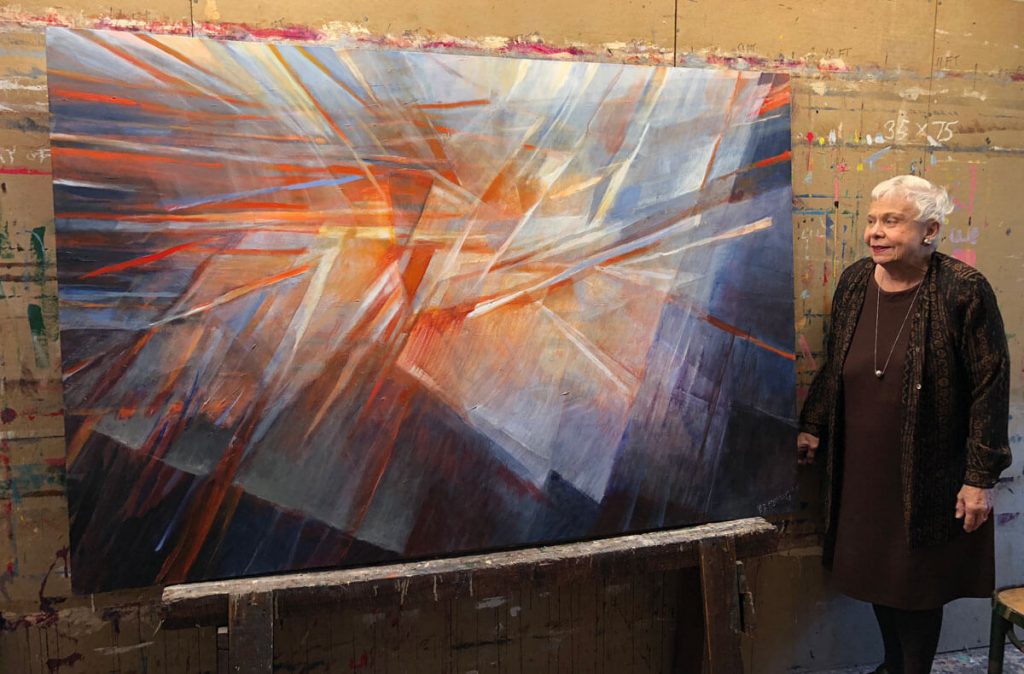 Rochelle Blumenfeld standing near "Play of Light" painting
